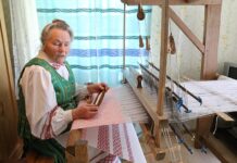 A. Araminienė puošiasi pačios austais tautiniais drabužiais